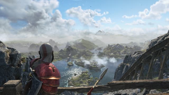 Kratos peers across some vivid Sfvartalfheim landscape from a high bridge.