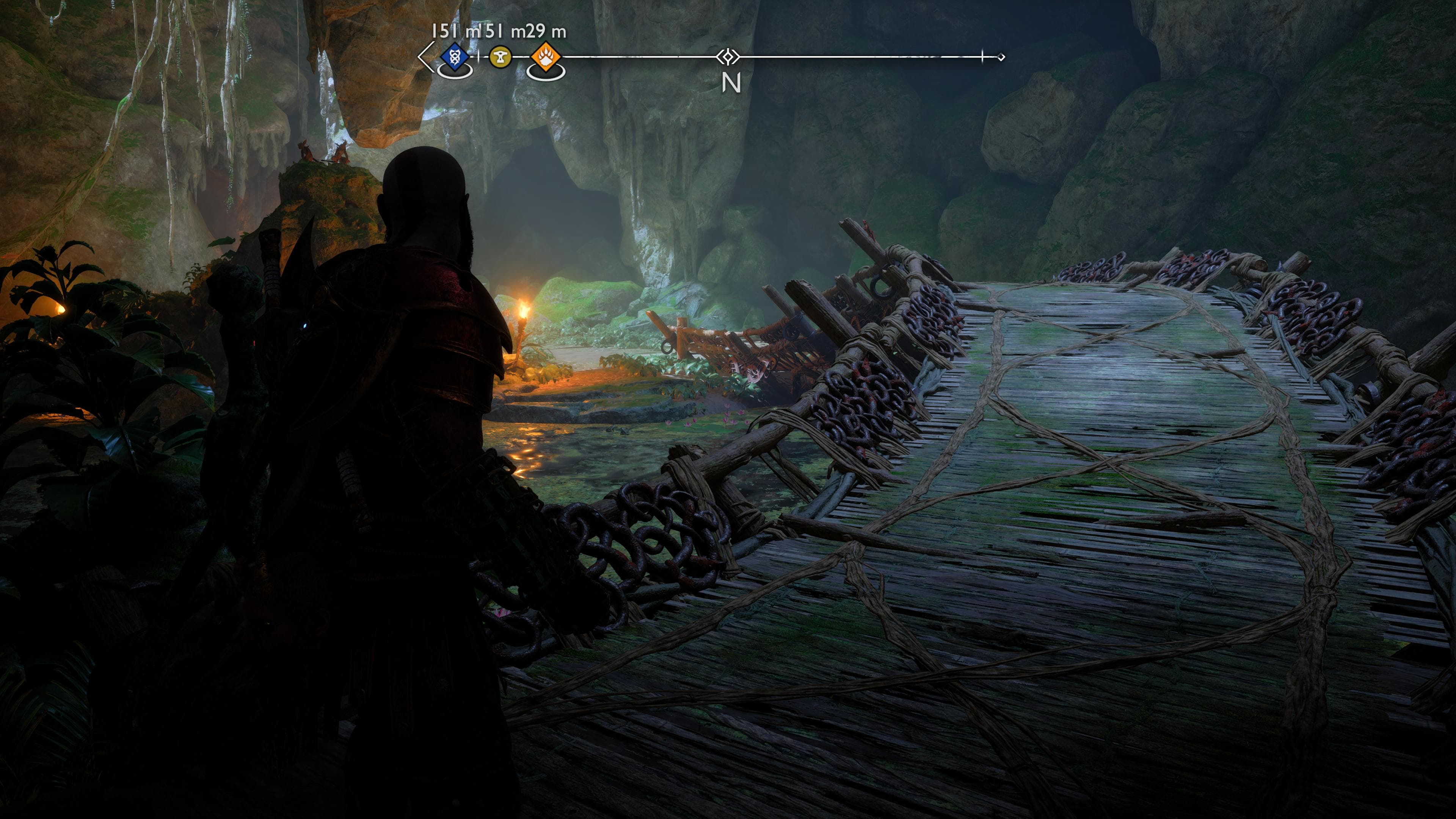 Kratos looks along a shaded bridge in vanaheim